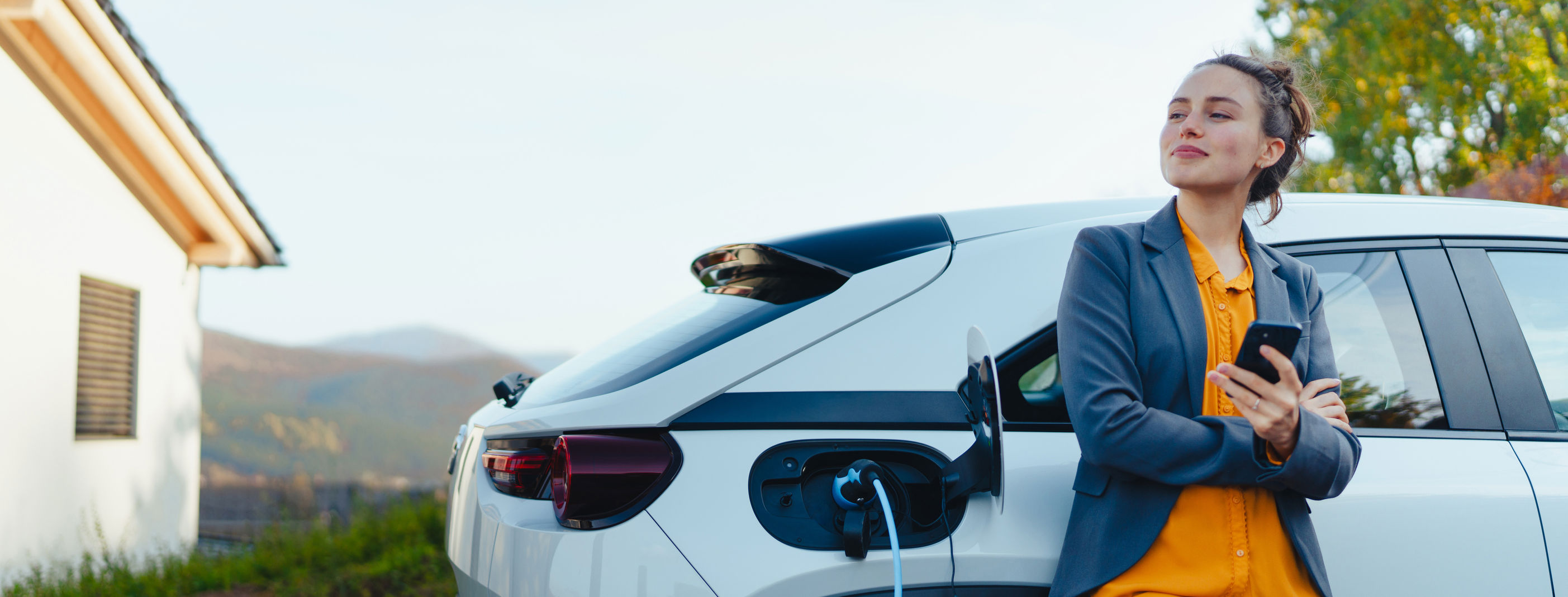 Woman stood by electric car