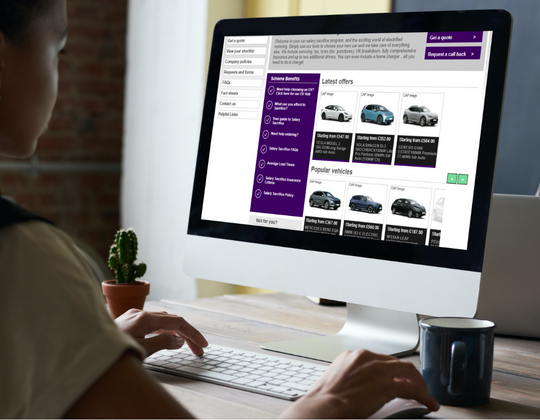Woman looking on computer at cars